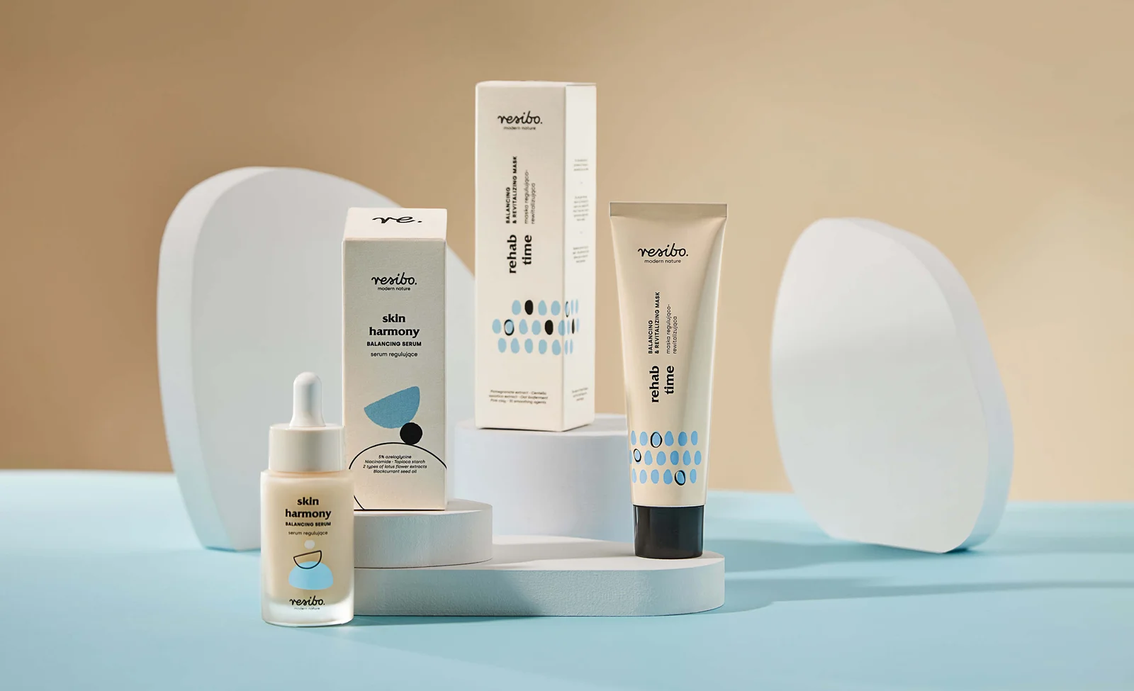Resibo Skin Harmony serum and Rehab Time mask packaging with blue illustrations on light-coloured plinths